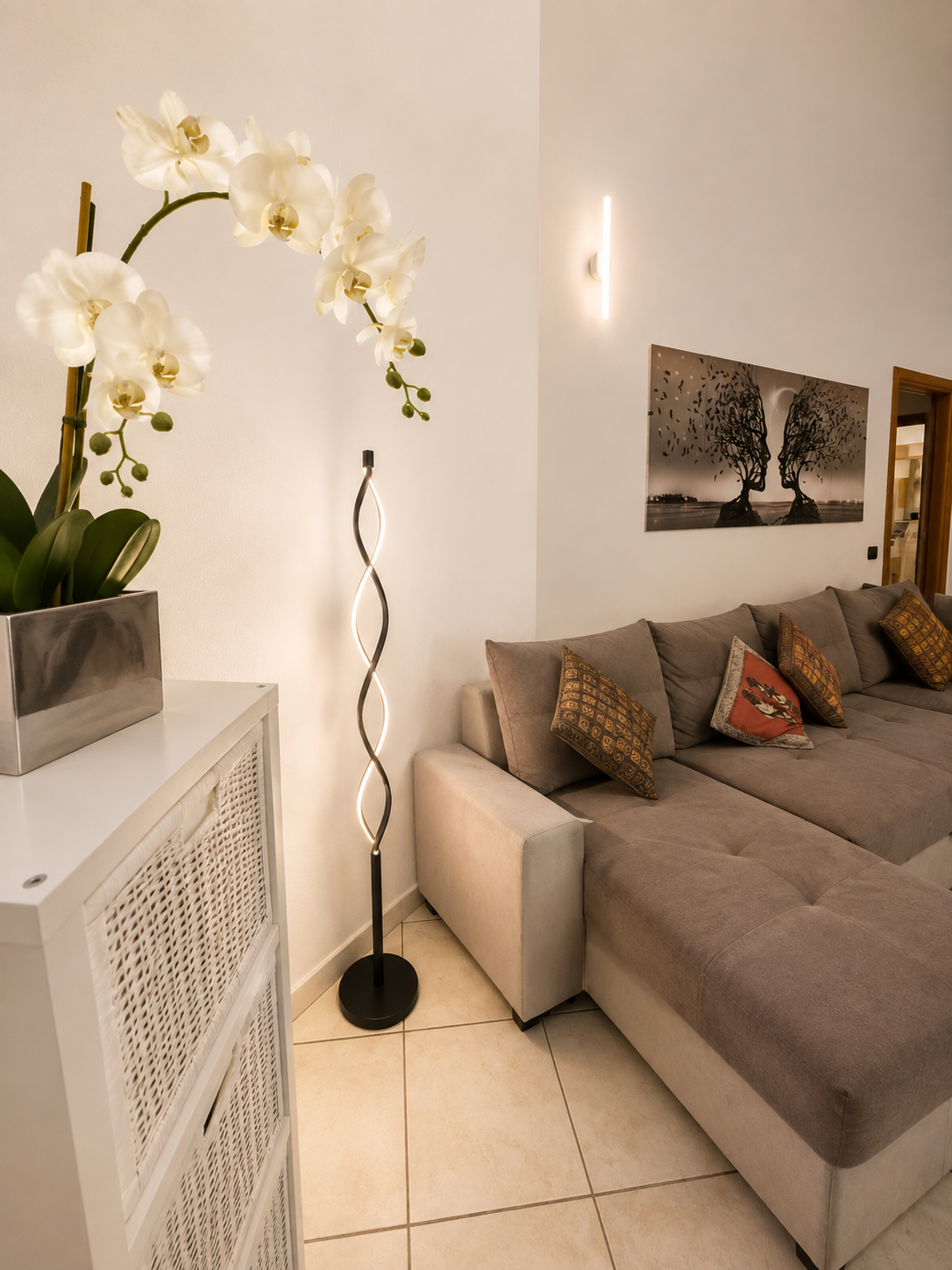Lounge detail with orchid, sculptural floor lamp and woven storage unit