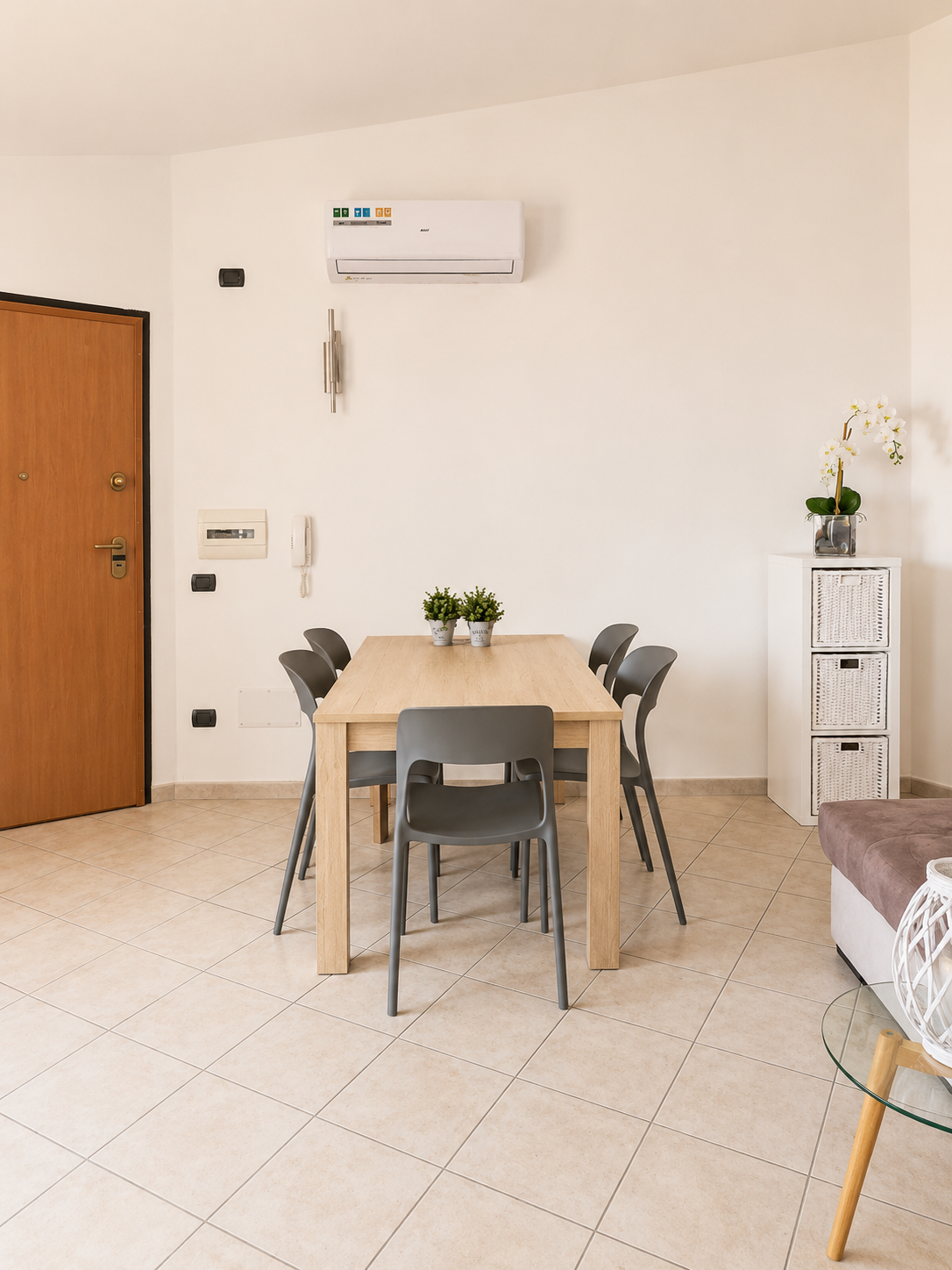 Oak dining table for six with grey chairs beside the private entrance